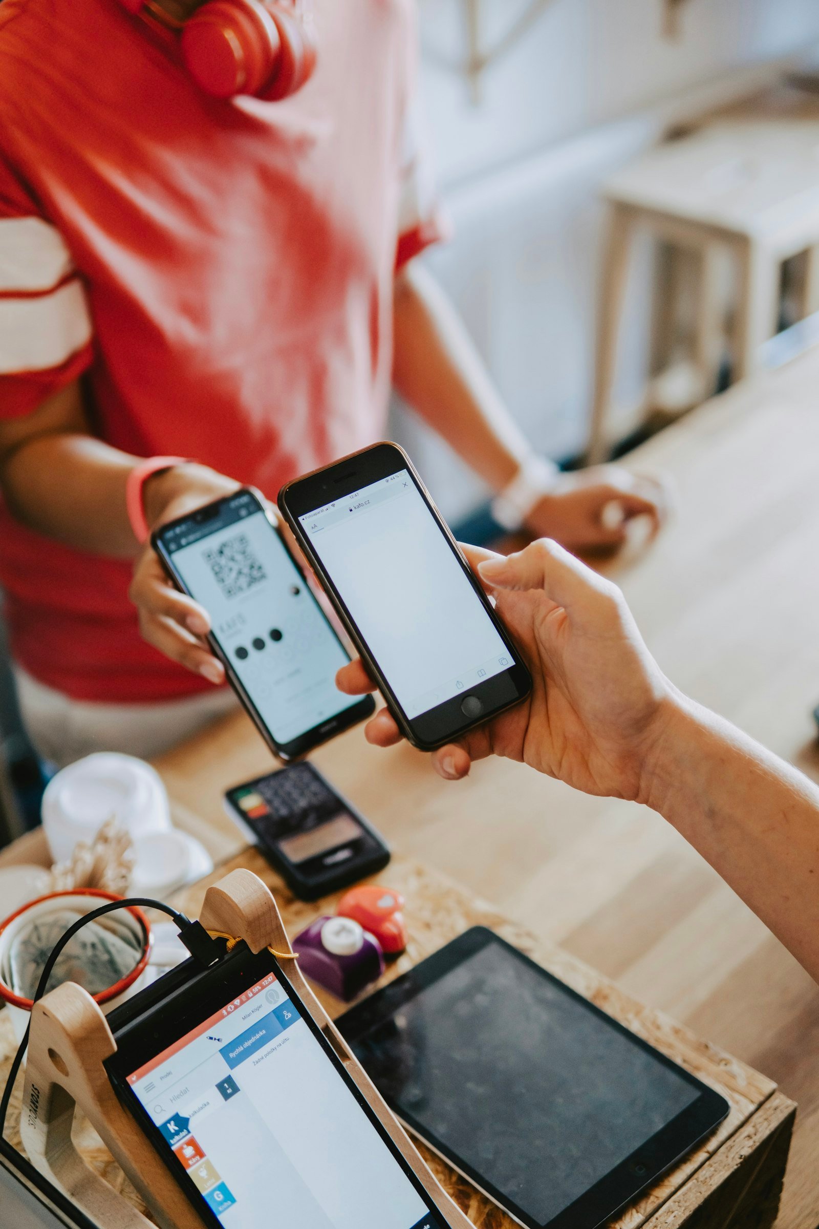 One person holding up a phone showing a QR code while another scans it to send a cashless gift — the scan-to-give flow churches can use for online tithes and offerings