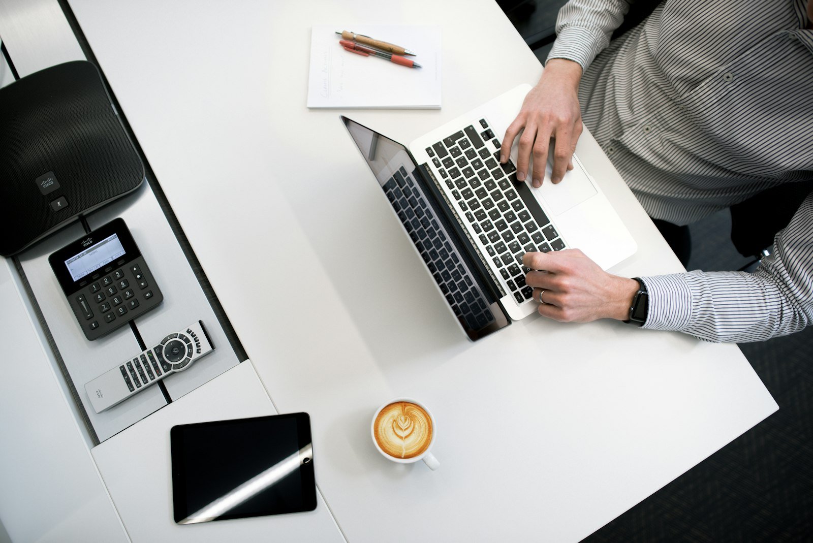Close-up of hands typing on a laptop at a wooden desk, drafting a business email