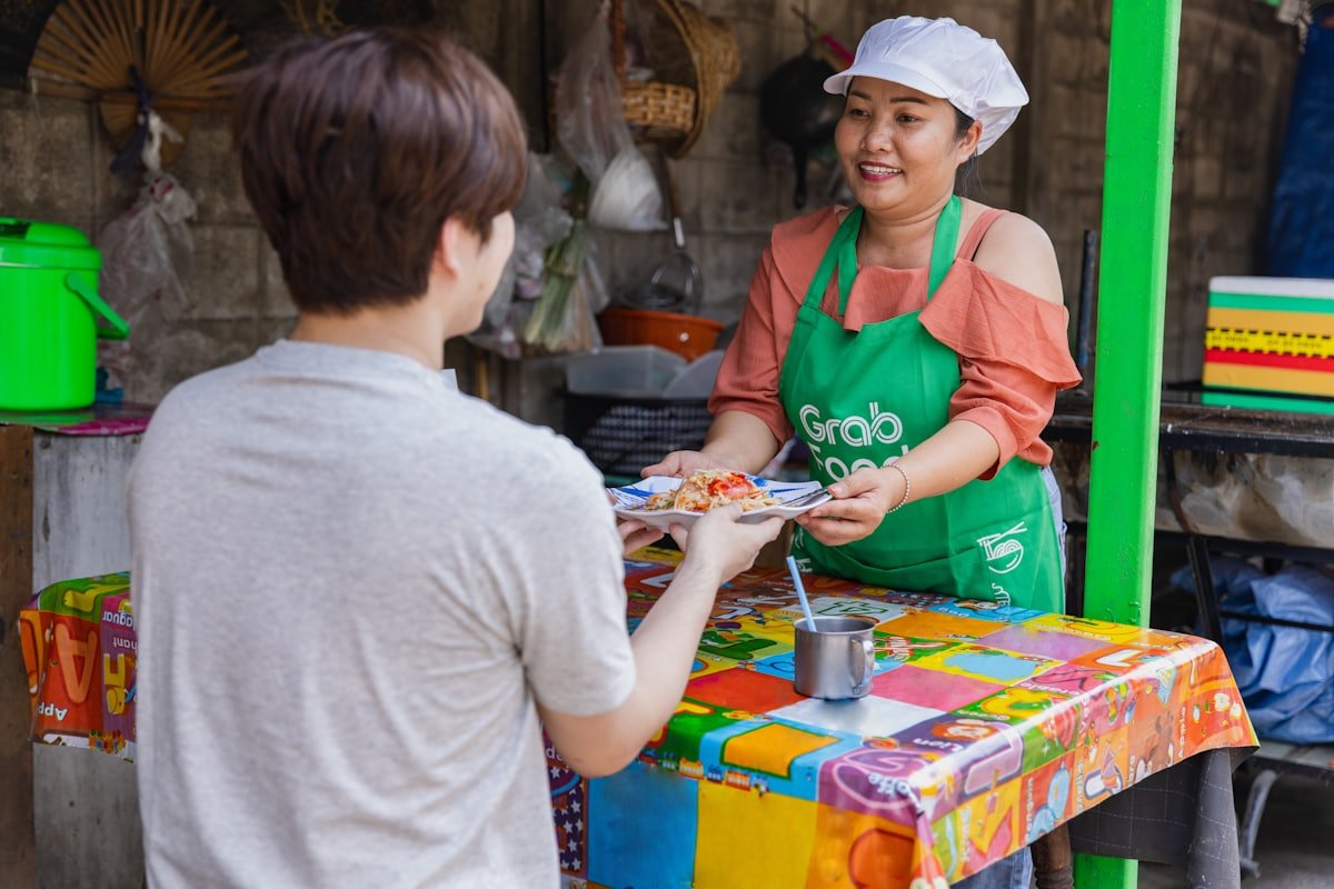 Filipina food vendor smiling while serving a customer